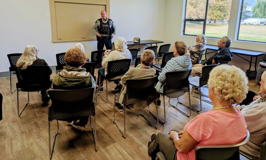 An RCMP officer provides fraud prevention tips at a security seminar during the Village of Lumby’s first Seniors Wellness and Food Fair, held Oct. 21 at the White Valley Community Centre.