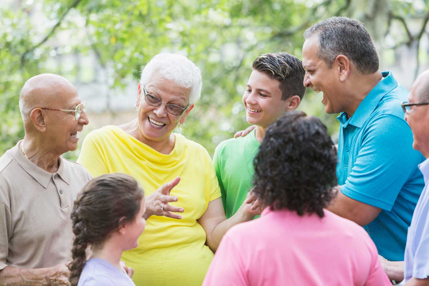 A group of people talk to an elderly woman